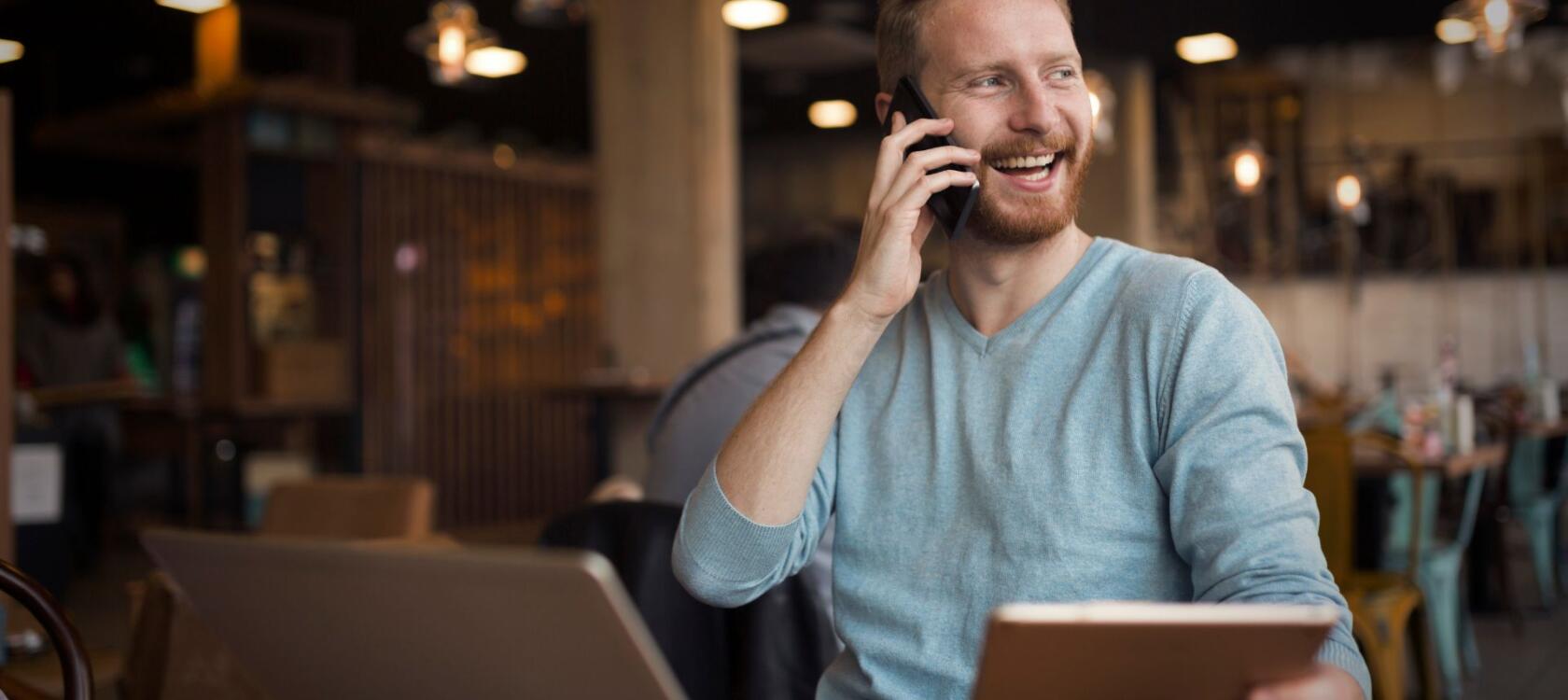 Man talking on phone reading laptop